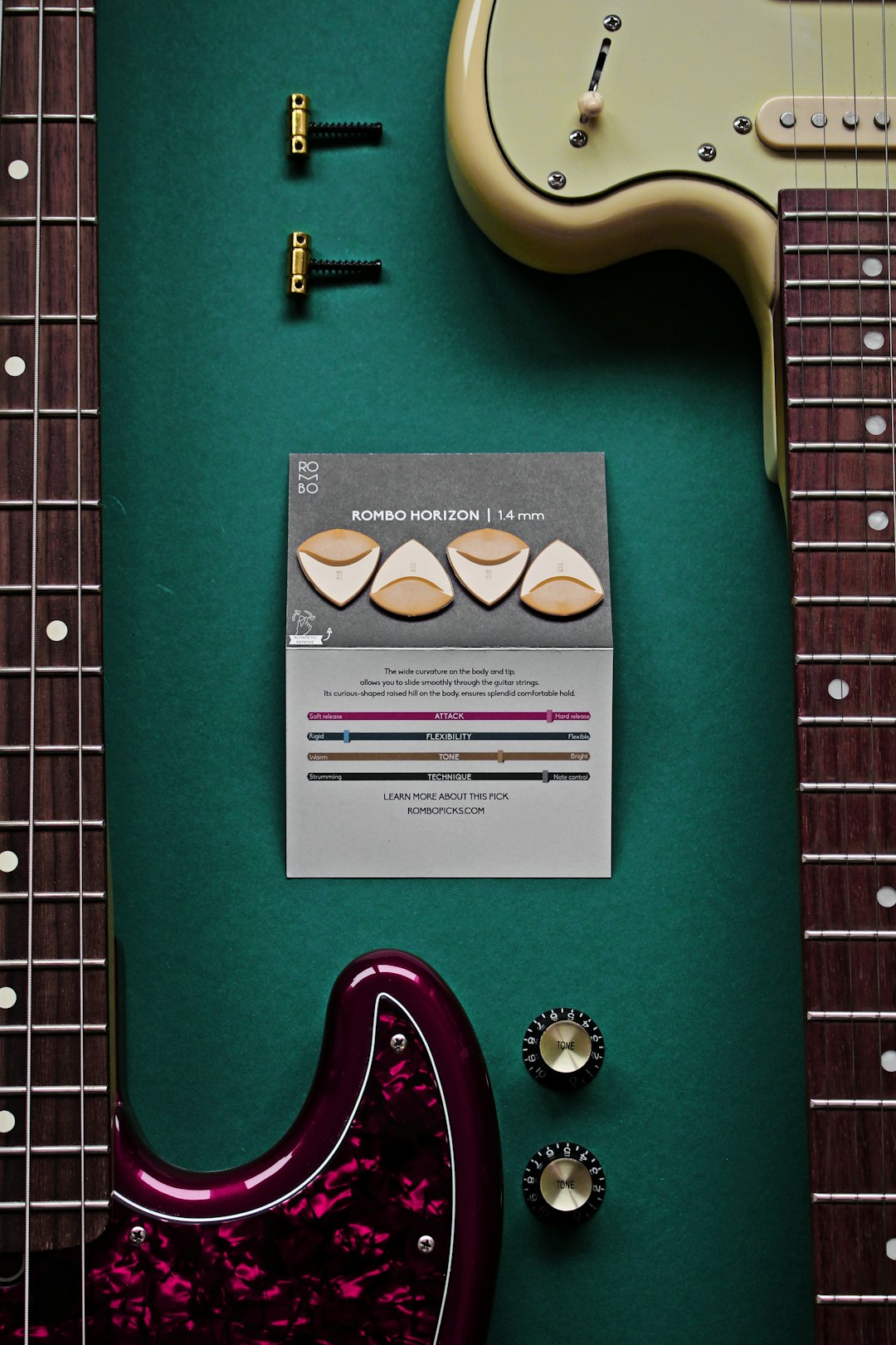 an electric guitar and a guitar tuner on a green surface